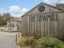 A sawmill building with a large wheel and outdoor area at The Sawmill in Seascale