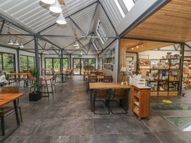 A café with tables and chairs and shelves containing various items at Irt Cottage in Seascale