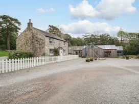 An outdoor view of a house and storage building at Irt Cottage Seascale