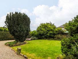 A garden with trees and grass at Prudhoe Cottage in Prudhoe