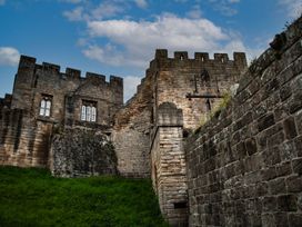 A stone castle structure with grass in front at Prudhoe Cottage in Prudhoe
