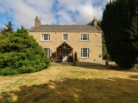 A house with a front porch and garden at Prudhoe Cottage in Prudhoe