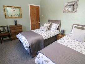 A bedroom with twin beds and a wood nightstand at Prudhoe Cottage in Prudhoe