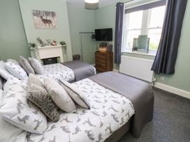 A bedroom with two beds and a television at Prudhoe Cottage in Prudhoe