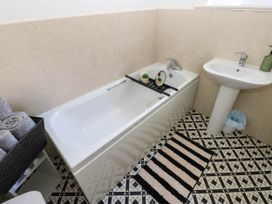A bathroom with a bathtub and sink at Prudhoe Cottage in Prudhoe