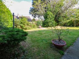 A garden area with grass, trees, and a plant pot at Prudhoe Cottage in Prudhoe