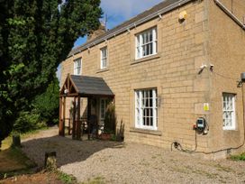 A house with a porch and driveway at Prudhoe Cottage in Prudhoe