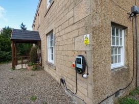 A building exterior with a window and charging station at Prudhoe Cottage in Prudhoe