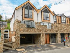 A modern building with multiple windows and a parking area at Beachstone in Salcombe