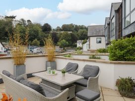 A patio area with outdoor furniture and planters at Beachstone in Salcombe