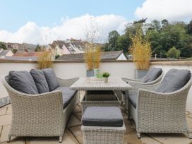 A seating area with a table and cushions at Beachstone in Salcombe