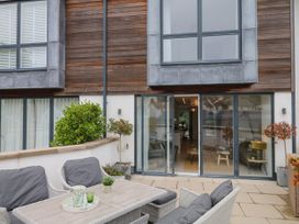 A patio with outdoor furniture and plants at Beachstone in Salcombe