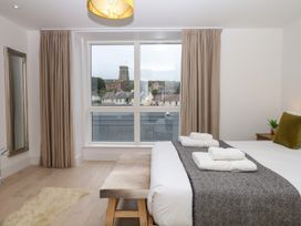 A bedroom with a bed and window at Beachstone in Salcombe