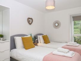 A bedroom with two beds and a window at Beachstone in Salcombe
