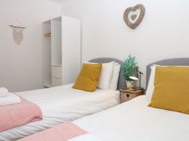 A bedroom with two beds and a wardrobe at Beachstone in Salcombe