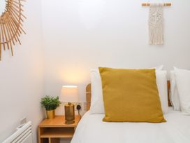 A bedroom with a yellow pillow and lamp at Beachstone in Salcombe