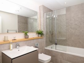 A bathroom with a sink, shower, and bathtub at Beachstone in Salcombe
