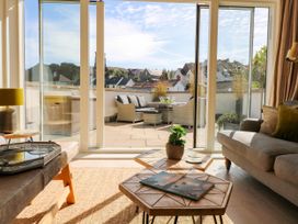 A living room with glass doors leading to an outdoor seating area at Beachstone in Salcombe