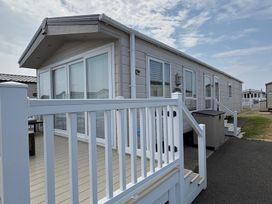 A mobile home with a deck and steps at Lyons Robin Hood in Rhyl