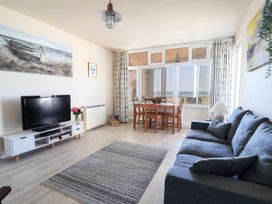 A living room with a sofa and dining table at 16 Old Shipyard Centre, West Bay