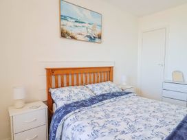 A bedroom with a bed and two bedside tables at 16 Old Shipyard Centre in West Bay