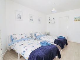 A bedroom with two beds and a lamp at 16 Old Shipyard Centre West Bay