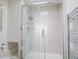 A bathroom with a shower and a mirror at 16 Old Shipyard Centre, West Bay