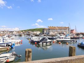 A harbor with boats and buildings at 16 Old Shipyard Centre in West Bay