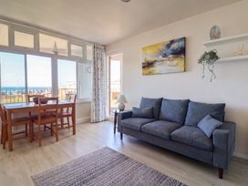 A living room with a dining table and ocean view at 16 Old Shipyard Centre West Bay