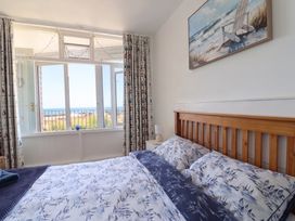A bedroom with a bed and window overlooking the sea at 16 Old Shipyard Centre West Bay