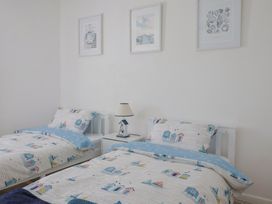 A bedroom with two beds and wall art at 16 Old Shipyard Centre, West Bay