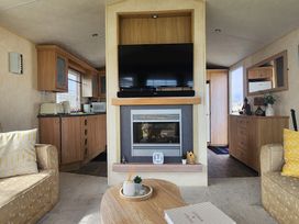 A living room with a fireplace and television at Whitley bay parkdean resorts - 52 Beechfield in Whitley Bay