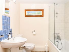 A bathroom with a bathtub and wash basin at Dashel Cottage at Dockwell Farm near Widecombe-In-The-Moor