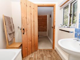A bathroom with a bath, sink, and towels at Dashel Cottage at Dockwell Farm near Widecombe-In-The-Moor
