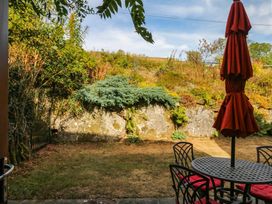 A garden with a patio table and an umbrella at Dashel Cottage at Dockwell Farm near Widecombe-In-The-Moor
