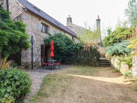 A garden with a table and chairs under a parasol at Dashel Cottage at Dockwell Farm near Widecombe-In-The-Moor