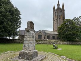 A church tower and stone monument in a grassy area at Dashel Cottage at Dockwell Farm Widecombe-In-The-Moor