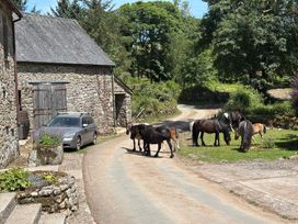 A scene with horses near a stone building at Dashel Cottage at Dockwell Farm Widecombe-In-The-Moor
