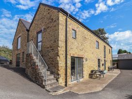 An outdoor view of a stone building with stairs and patio at The Old Dairy near Liskeard
