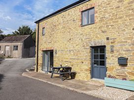 An outdoor seating area with a table and chairs at The Old Dairy near Liskeard