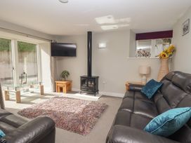 A living room with a television and a stove at The Old Dairy near Liskeard