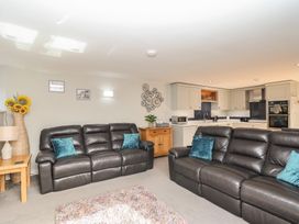 A living room with seating and kitchen area at The Old Dairy near Liskeard