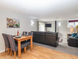 A living room with a dining area and a television at The Old Dairy near Liskeard