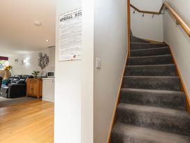 A living room with a staircase and furniture at The Old Dairy near Liskeard