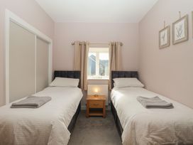 A bedroom with two single beds and a window at The Old Dairy near Liskeard