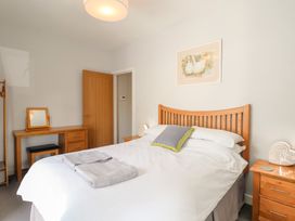 A bedroom with a bed and dresser at The Old Dairy near Liskeard