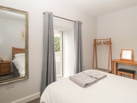 A bedroom with a bed and dresser at The Old Dairy near Liskeard