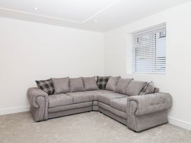 A living room with a grey sofa and window at Greenswood Mews in Brixham