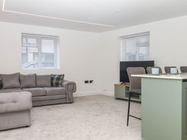 A living room with a sofa and television at Greenswood Mews in Brixham