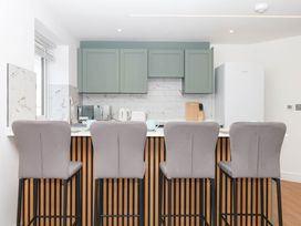 A kitchen with bar stools and appliances at Greenswood Mews in Brixham